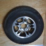 A tire mounted on a wooden wall.