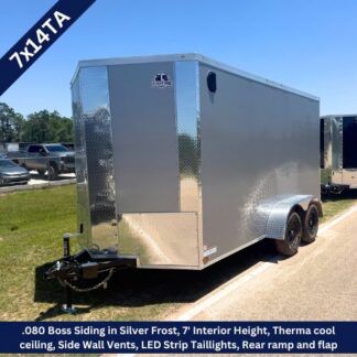 Enclosed silver cargo trailer with dual axles and a visible hitch on a parking lot. (7' interior height)