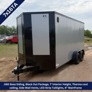 Enclosed cargo trailer with a black-and-gray two-tone exterior and dual axles, hitch at the front and a ramp-style opening at the back.