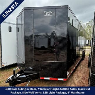 Black enclosed cargo trailer (8.5x28TA) with diamond-plate front and hitch in the foreground; branding reads Titanum Cargo Trailers LLC on the rear door./