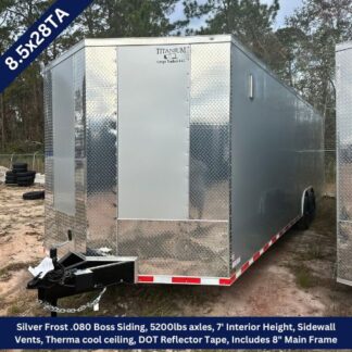 Silver diamond-plate cargo trailer with hitch and safety chains, side entry door, and DOT reflector tape along the lower edge, parked on a dirt lot.
