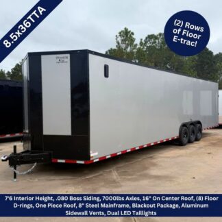Titanium Cargo 8.5×36 Silver Frost Triple Axle Enclosed Cargo Trailer with Black Out Package ‣ Boss Cargo Trailers Enclosed dual-axle cargo trailer on a dirt lot; highlights two rows of Floor E-trac, white with black front, side vents and red-white reflective trim along the base.